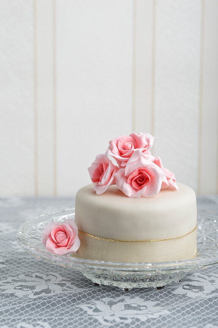 A mini tartlet with ready-roll icing decorated with sugar roses