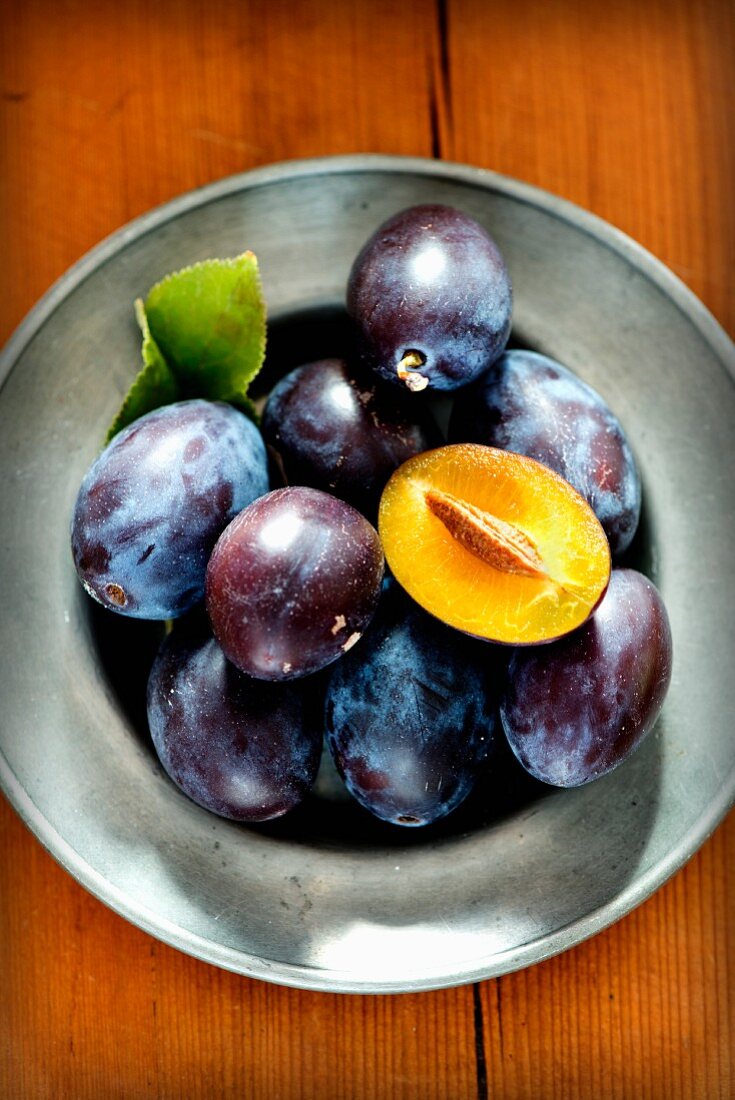 Fresh plums on a pewter plate