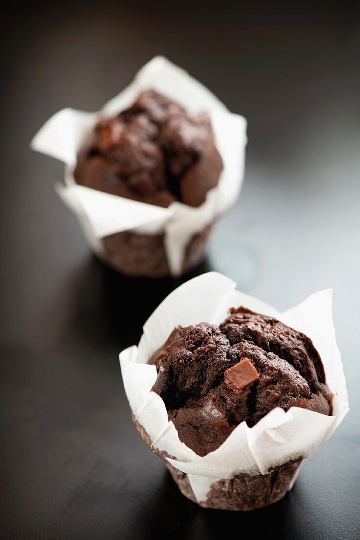 Zwei Schokoladen-Fudge-Muffins in weißem Papier