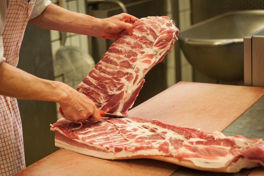A butcher carving pork
