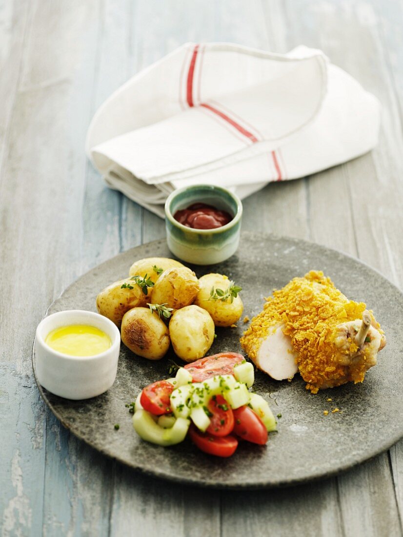 A chicken leg with a cornflakes crust and oven-roasted potatoes
