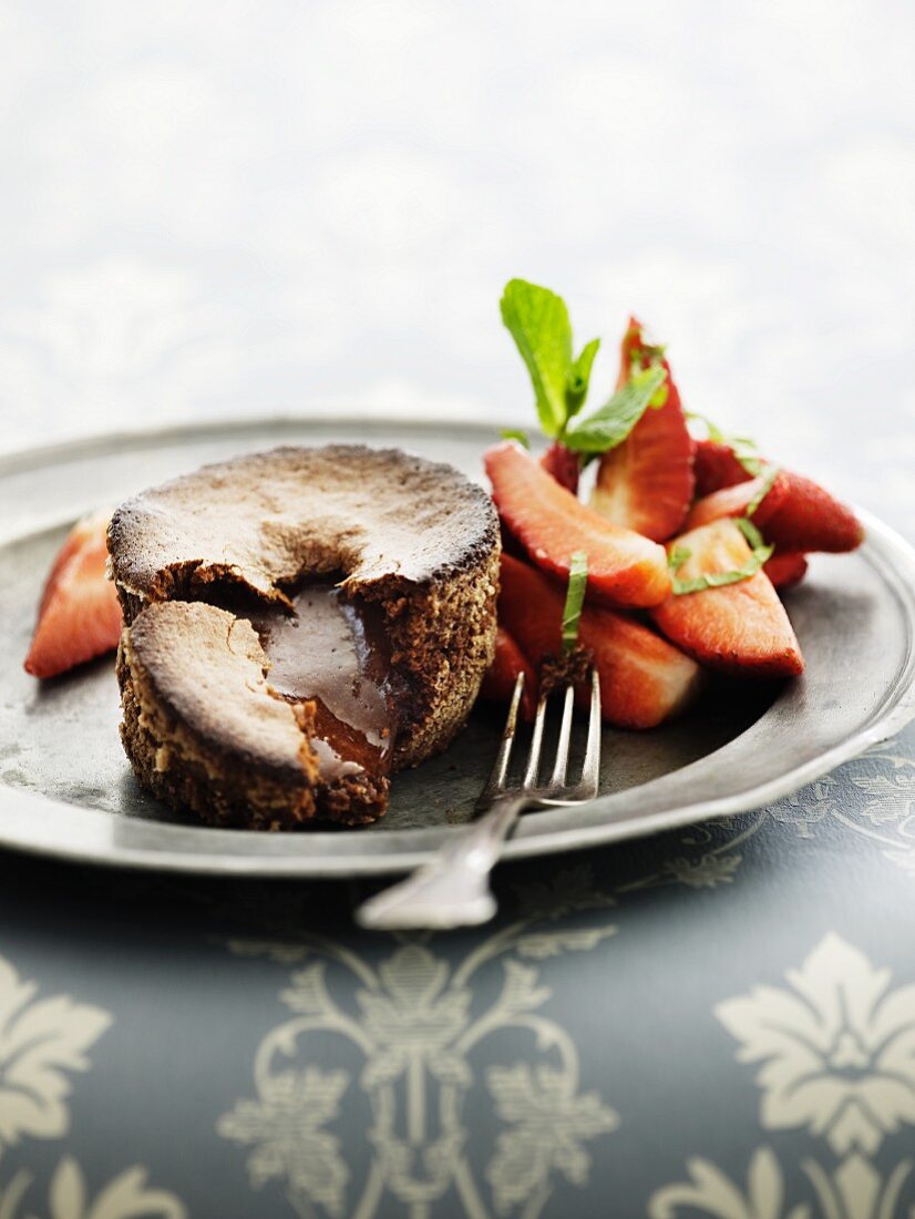 A chocolate tartlet with a liquid core and strawberries
