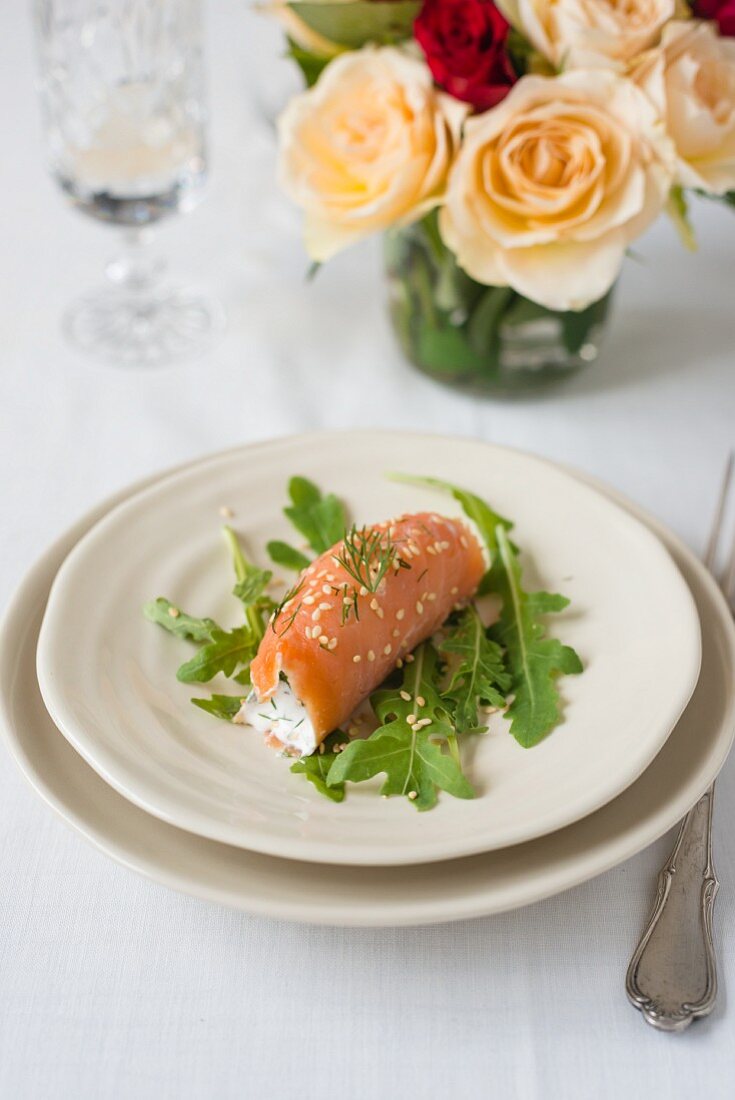 A smoked salmon roll with the yoghurt, sesame seeds and rocket