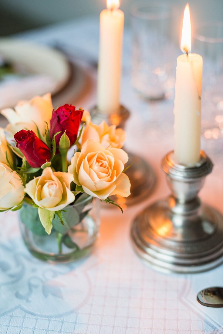 Tafelkerzen und Rosenstrauss als romantische Tischdeko