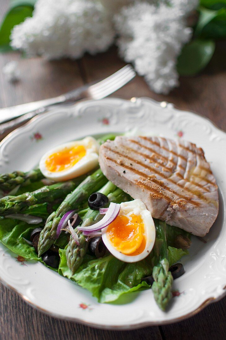 Nizzasalat mit Kopfsalat, Spargel, Ei, Zwiebeln, schwarzen Oliven und Thunfischsteak