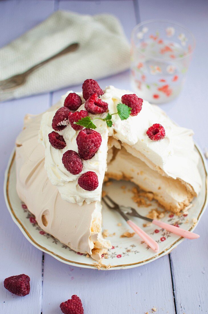 Pavlova (meringue cake) with mascarpone cream and fresh raspberries, sliced