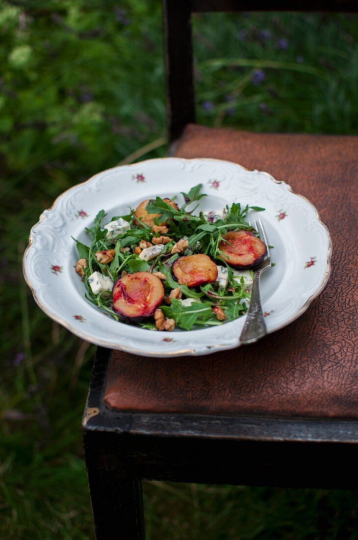 Salad with rocket, roasted plums, blue cheese and walnuts