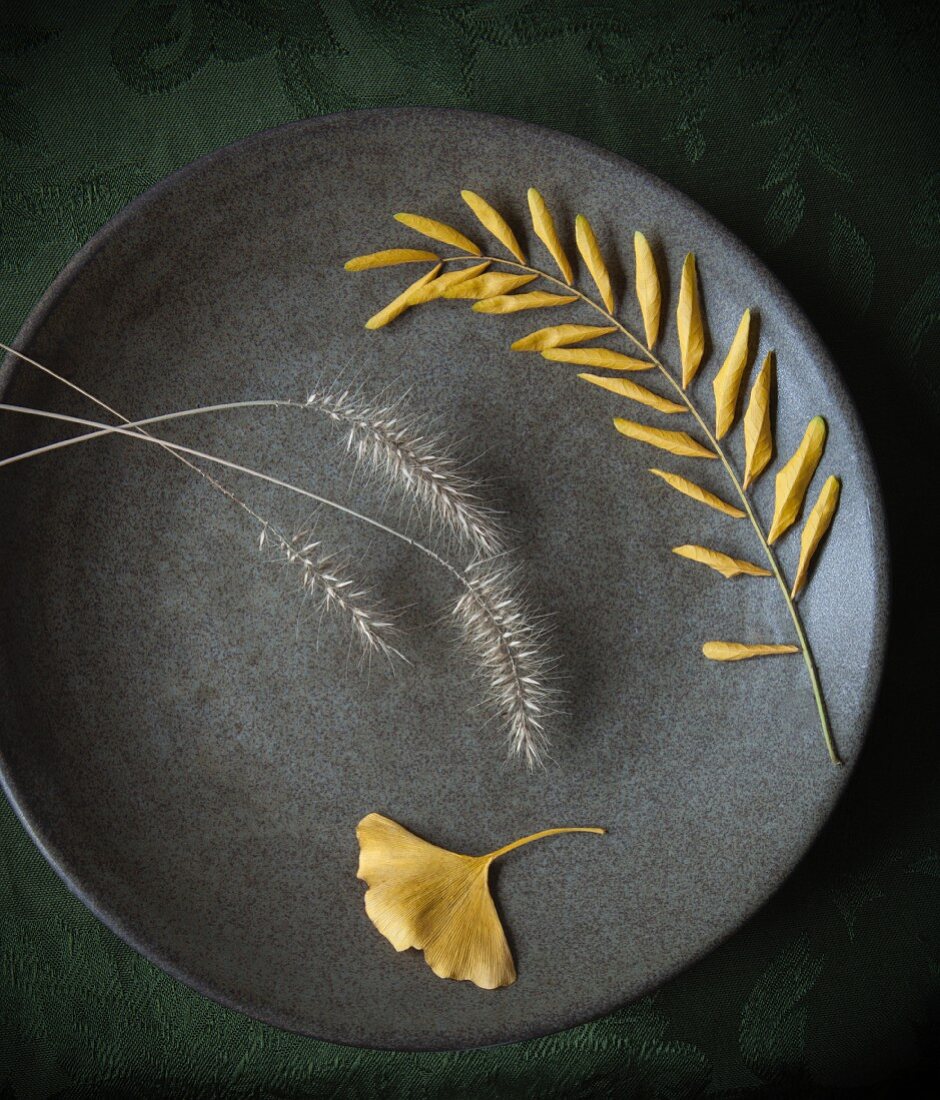 Yellow autumnal leaves and grasses on a plate