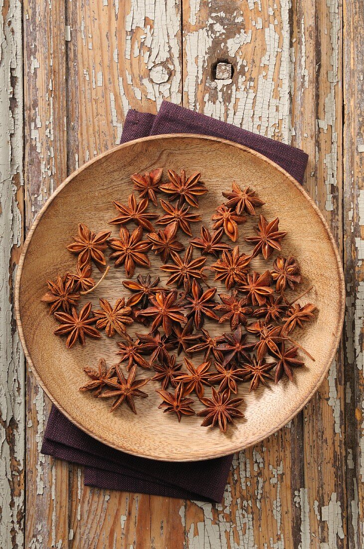 Anise stars on a wooden plate (seen from above)