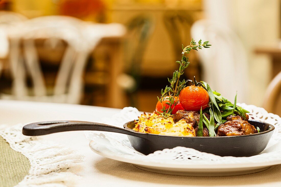 Pork with vegetables in a cast iron pan on a table