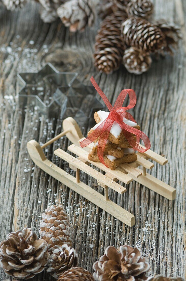 A stack of cinnamon star biscuits on a mini wooden sledge