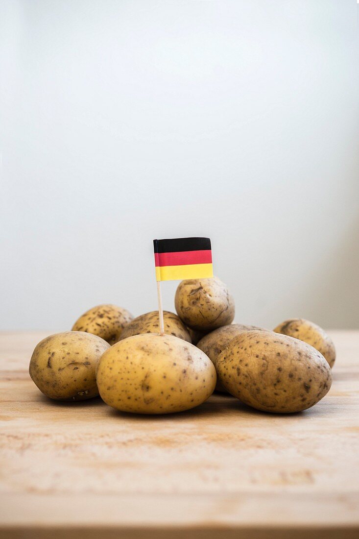 A paper German flag in the middle of a pile of potatoes