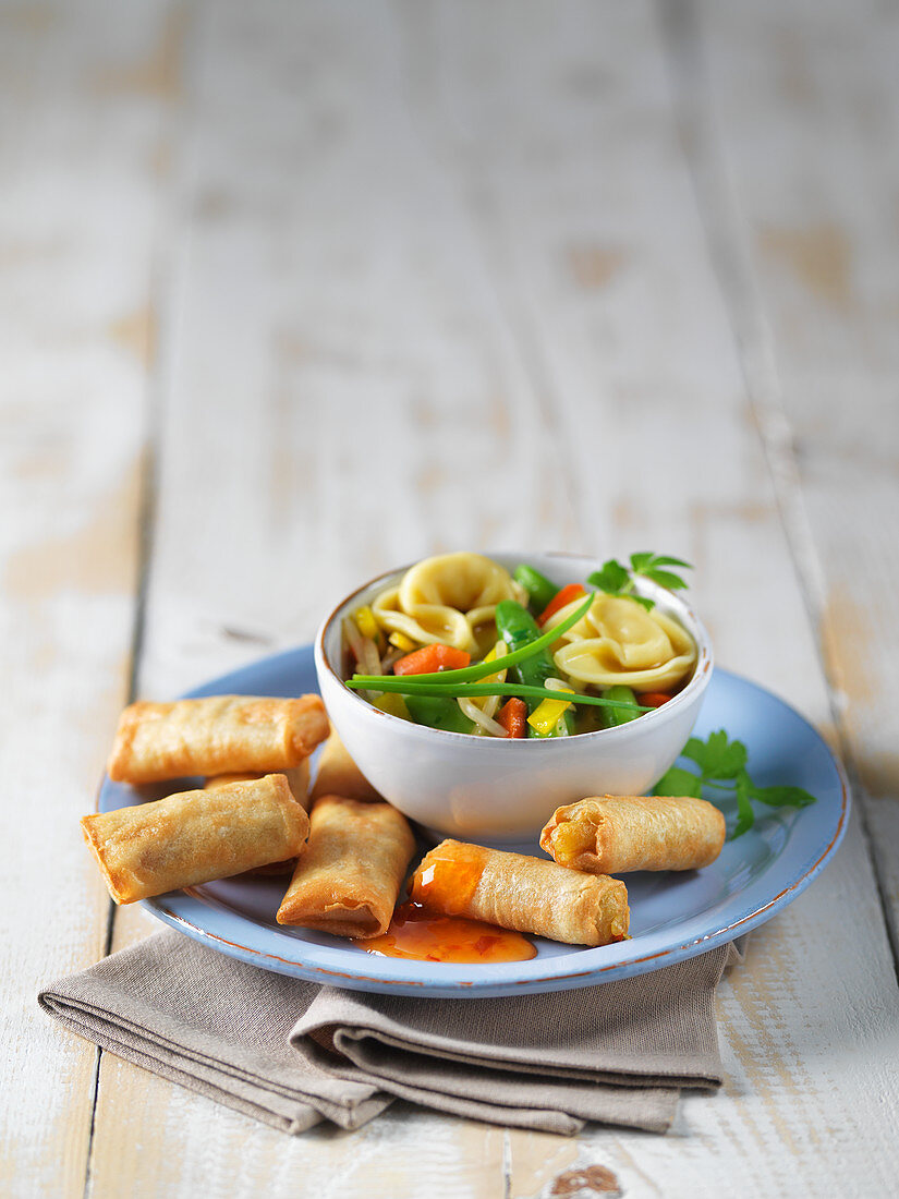 Mini spring rolls and vegetable soup on a plate