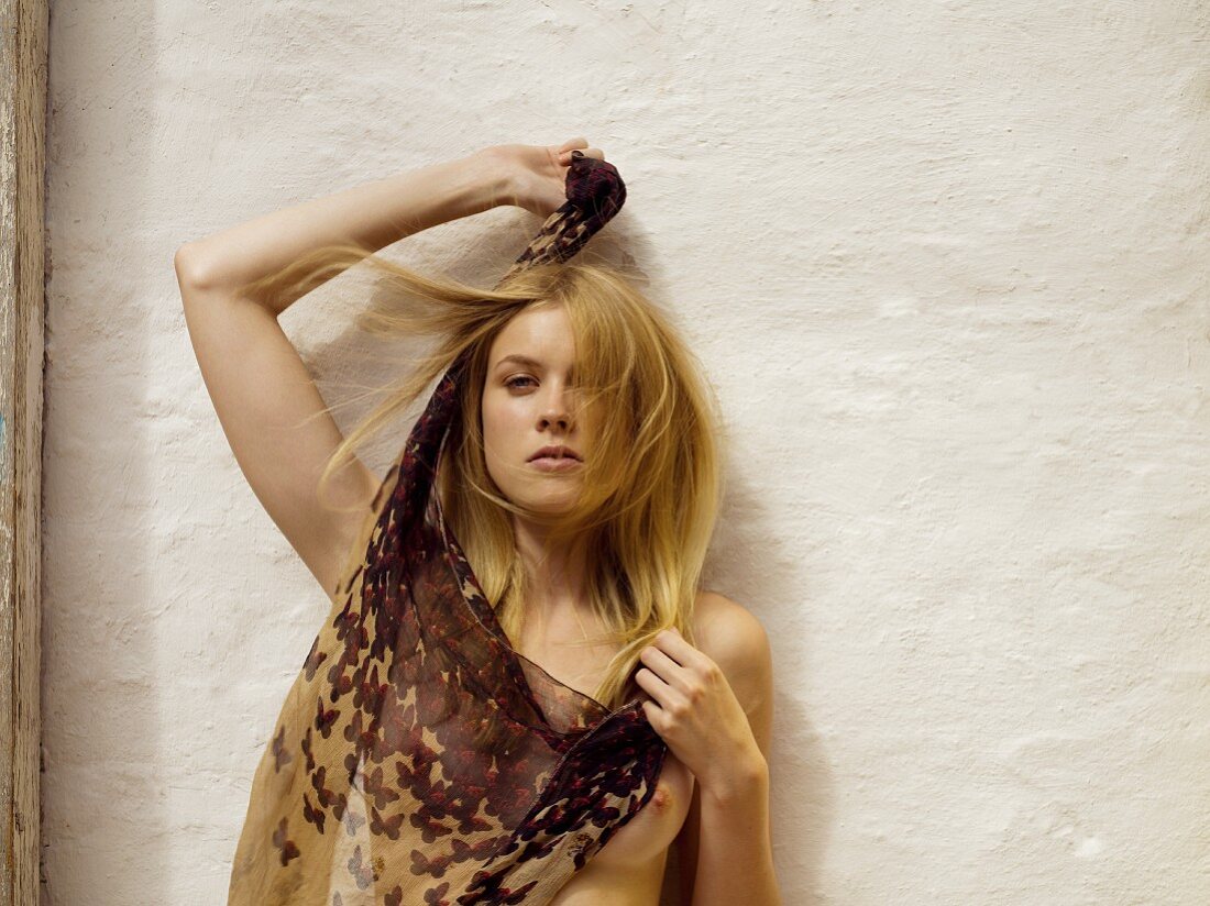 Young topless woman holding chiffon scarf