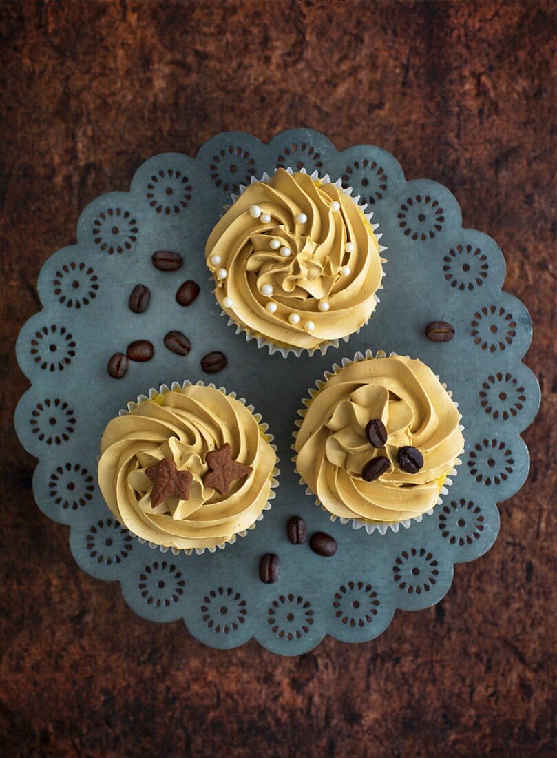 Three cupcakes decorated with coffee cream