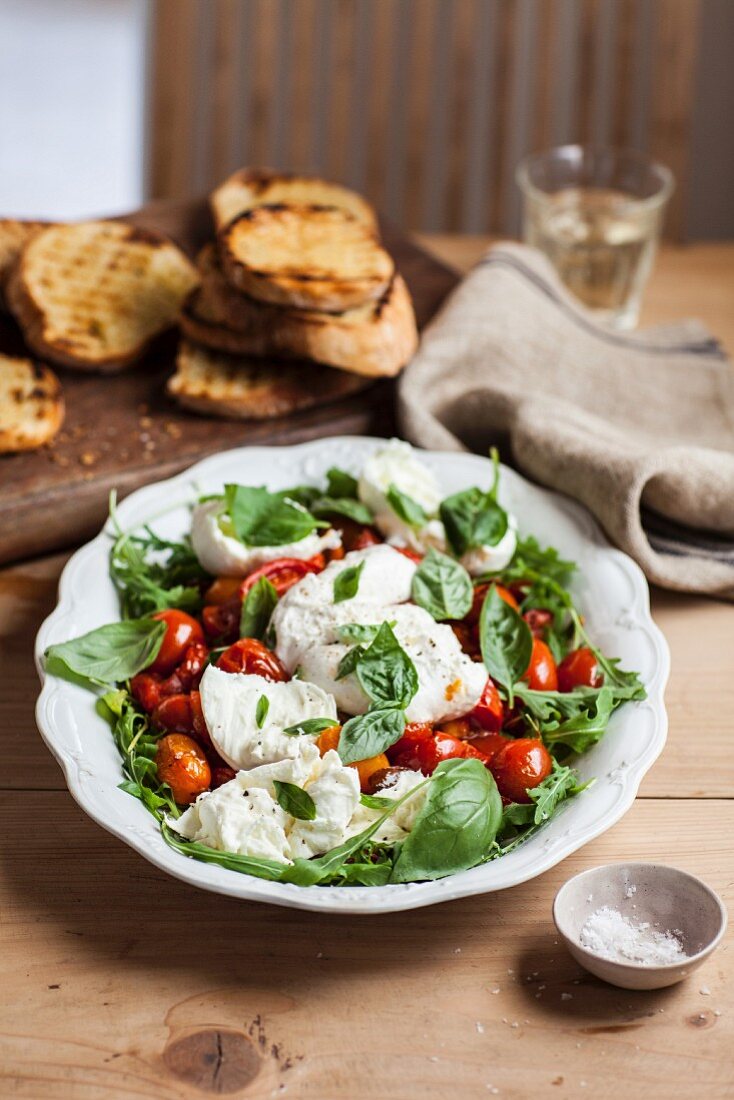 Braised tomatoes with mozzarella, rocket and basil