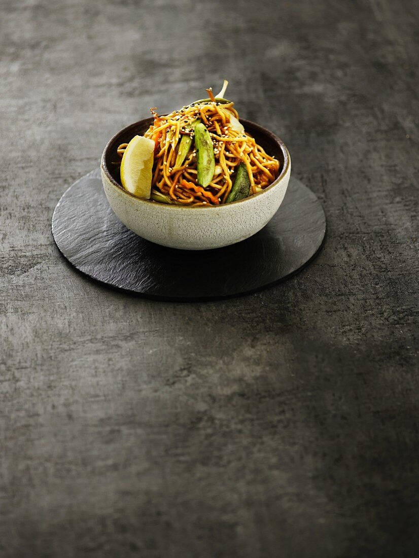 An Oriental vegetable dish with fried noodles and lemon