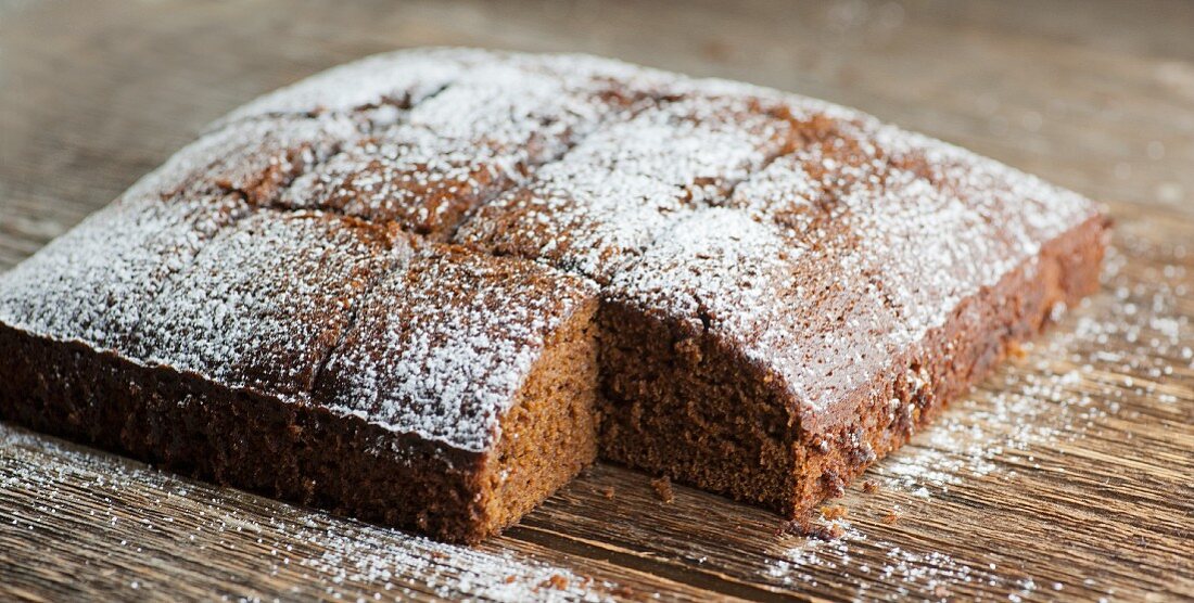 A square spiced cake with a slice cut out