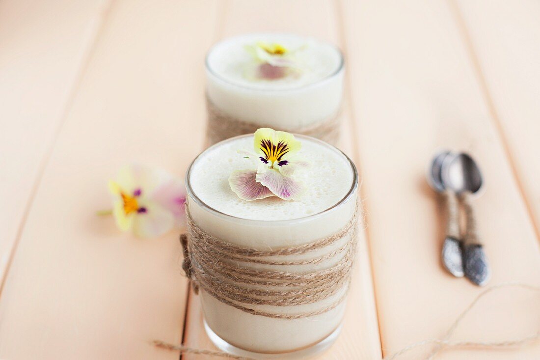 Light lemon cream with pansies on a light wooden surface