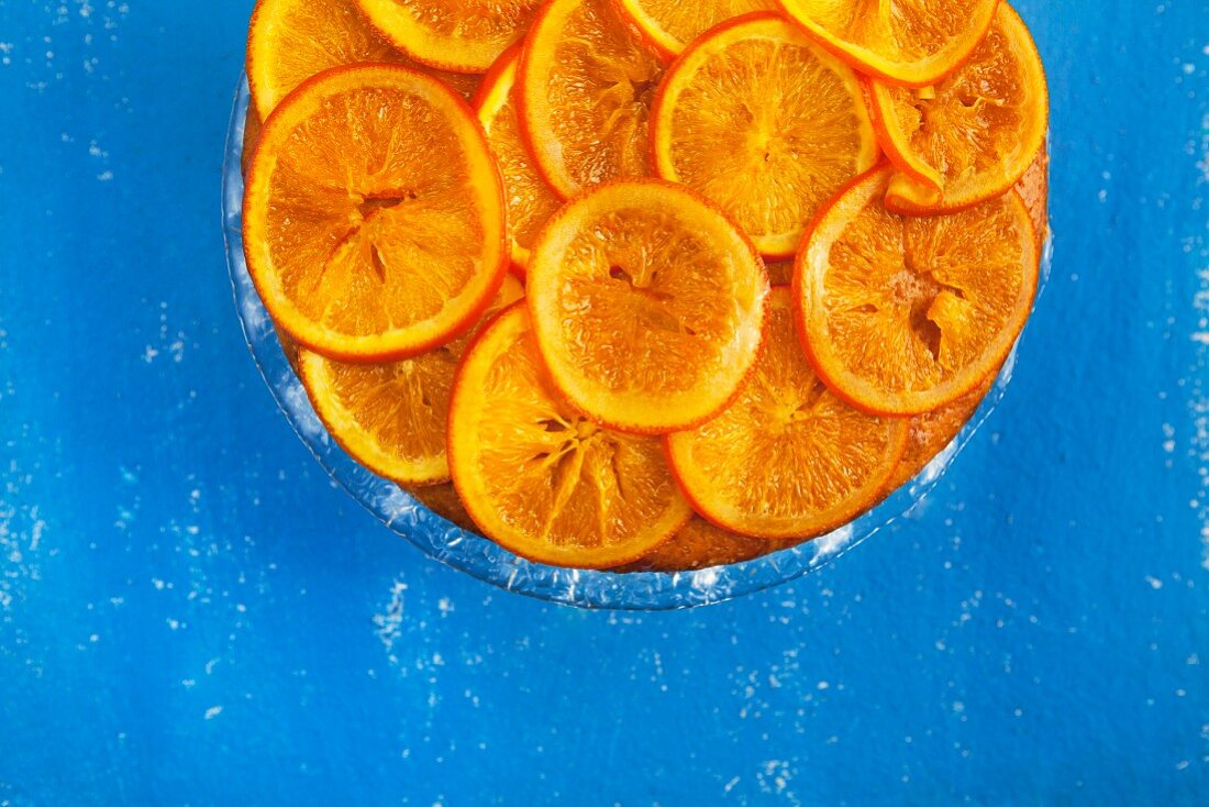 Orangenkuchen vor blauem Hintergrund (Draufsicht)