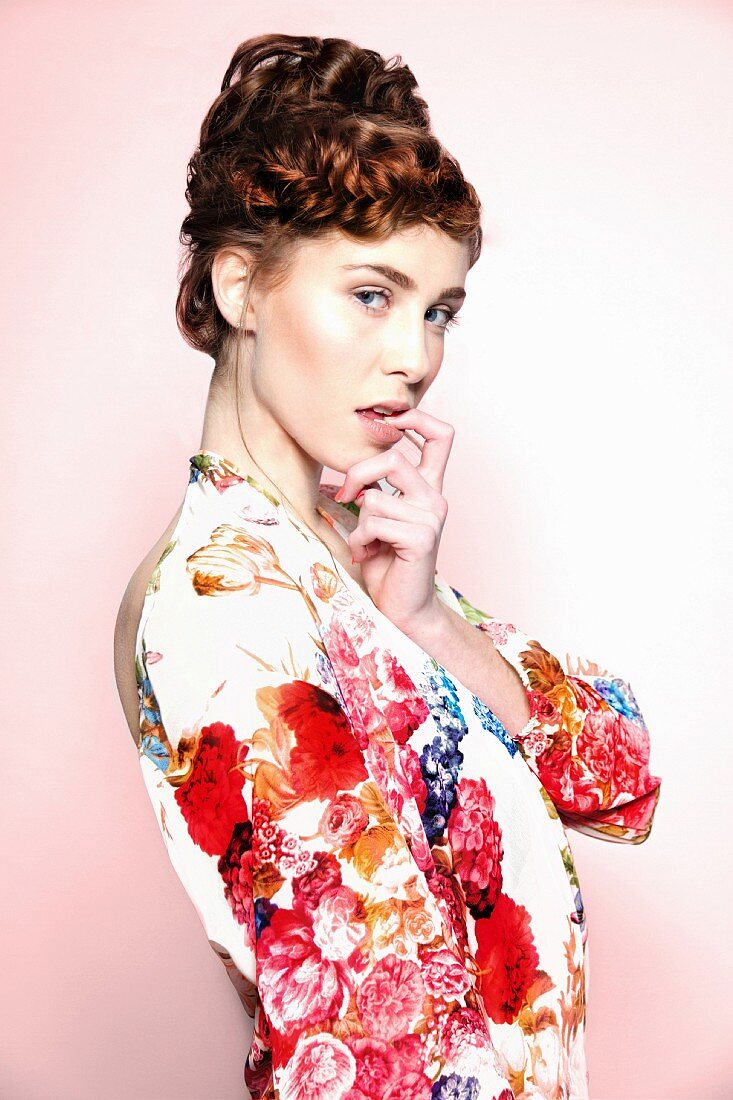 Young woman with curly pinned-up hairdo wearing floral dress