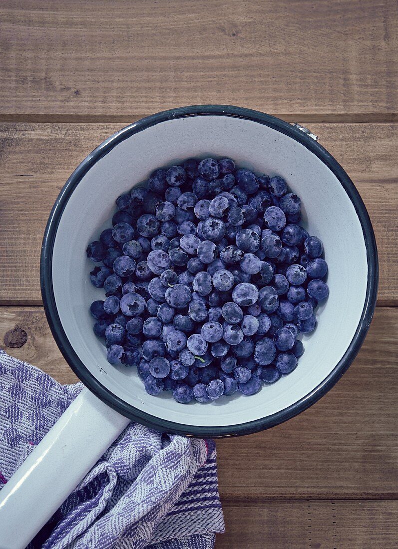 Blueberries in a white enamel saucepan