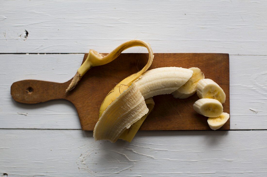 A banana on a wooden chopping board