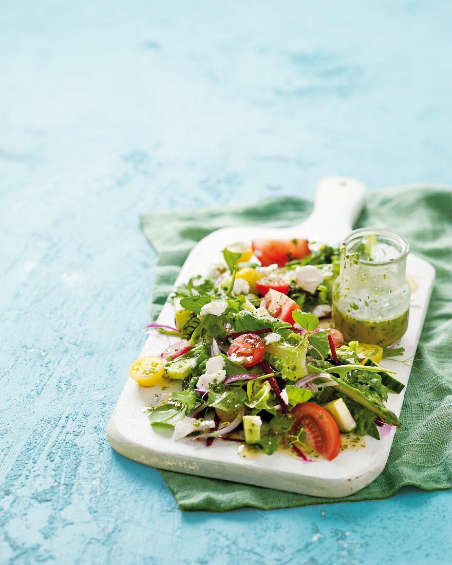 A summer salad with a herb vinaigrette on a chopping board