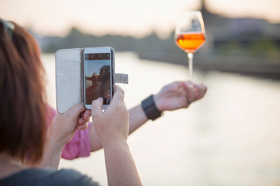 A woman photographing a drink with her smart phone