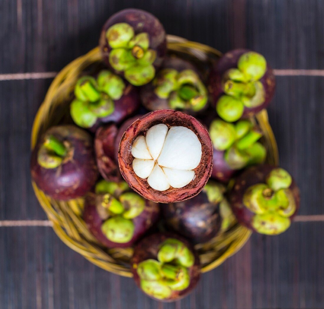 Fresh mangosteens in a basket (seen from above)