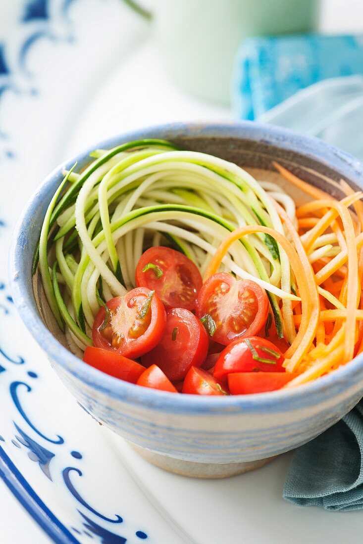 Healthy low fat salad of courgette and carrot spaghetti with cherry tomatoes