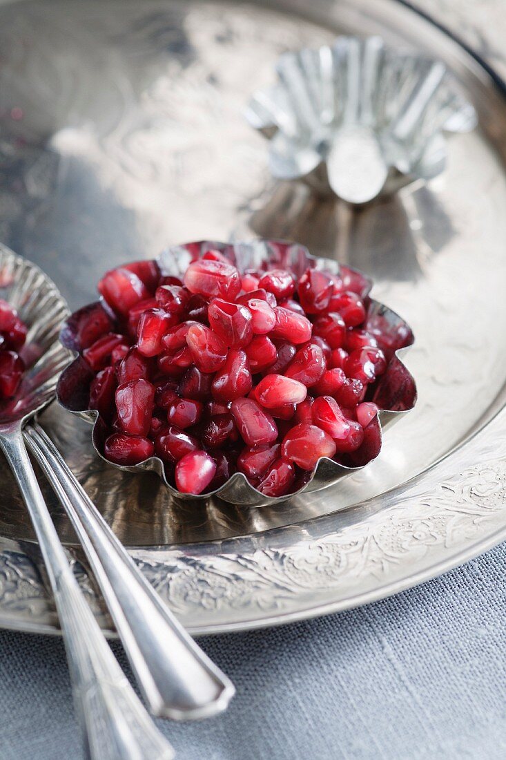 Pomegranate seeds in a metal bowl