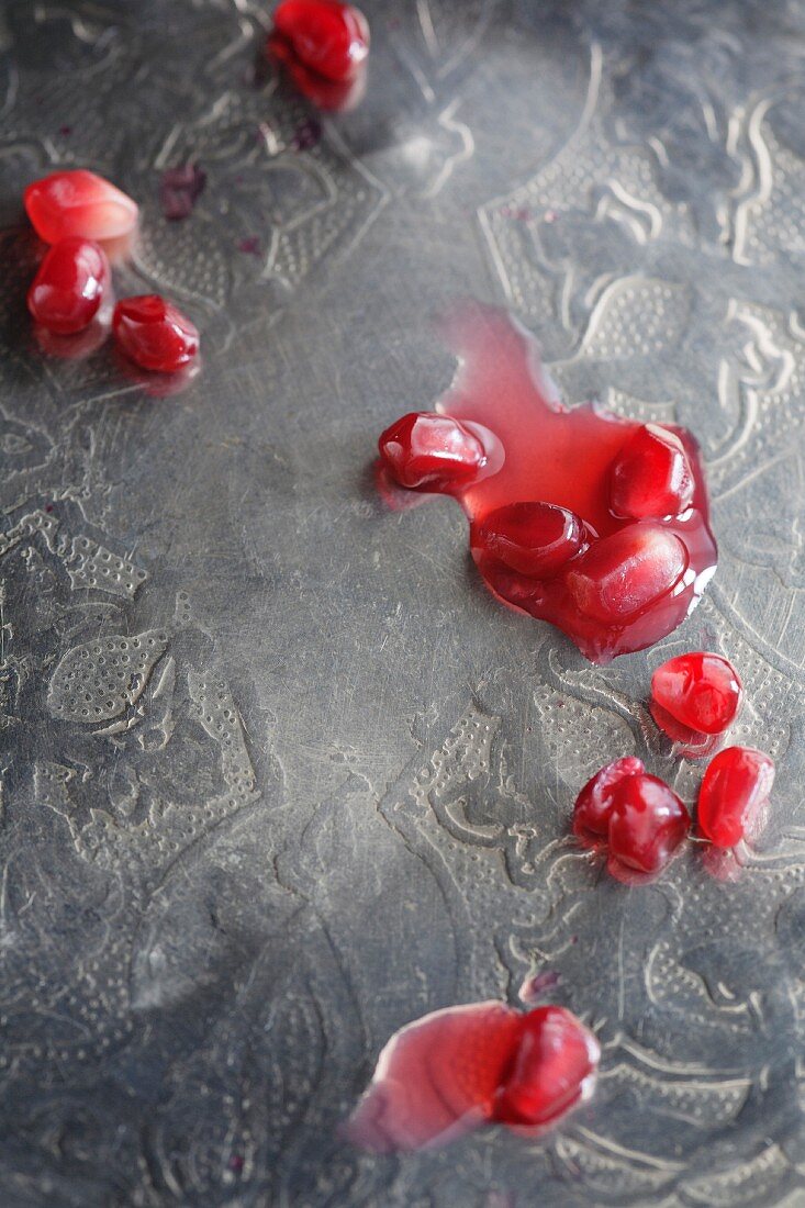 Pomegranate seeds on a silver tray