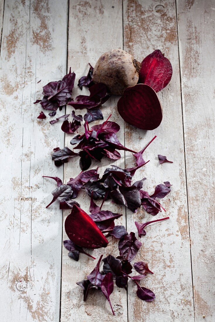 Fresh beetroot and beetroot leaves on a wooden surface