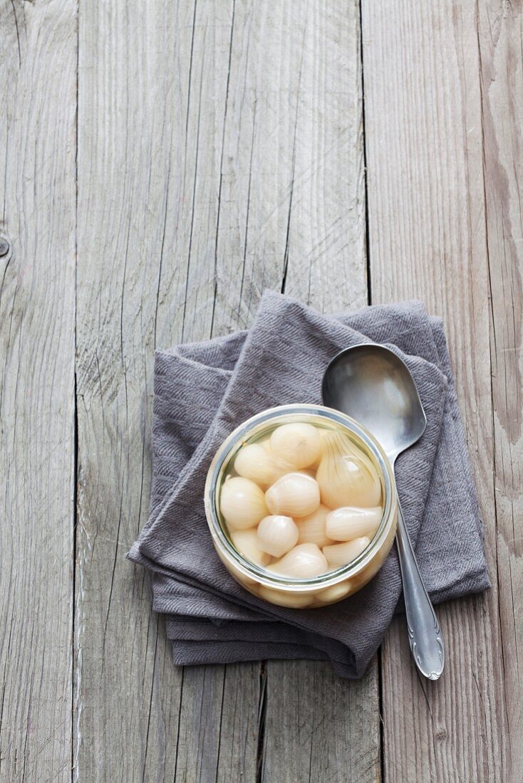 A jar of pickled pearl onions (seen from above)