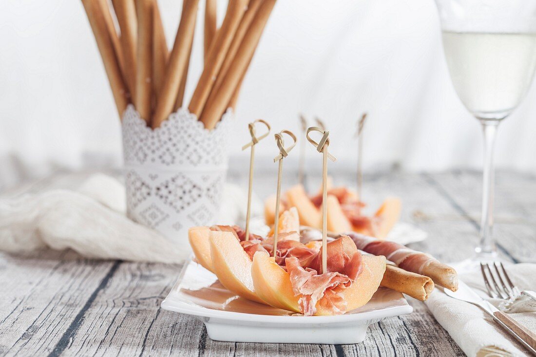 Melon boats and breadsticks wrapped in ham
