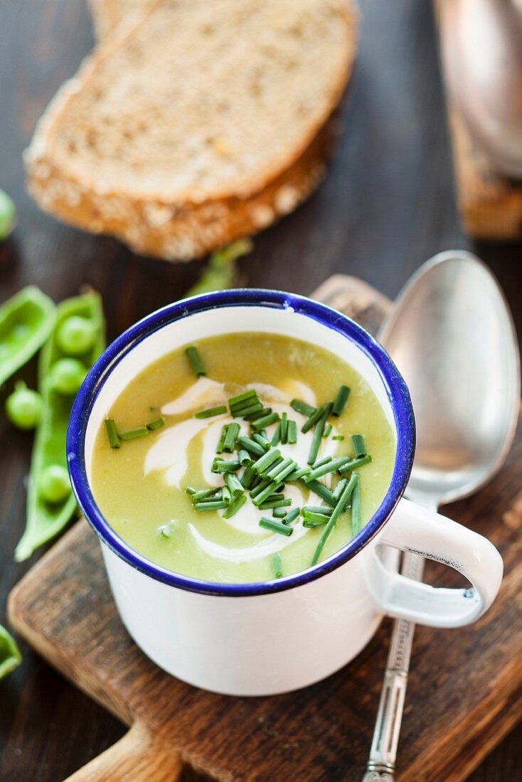 Erbsensuppe mit Schnittlauch in Emailletasse