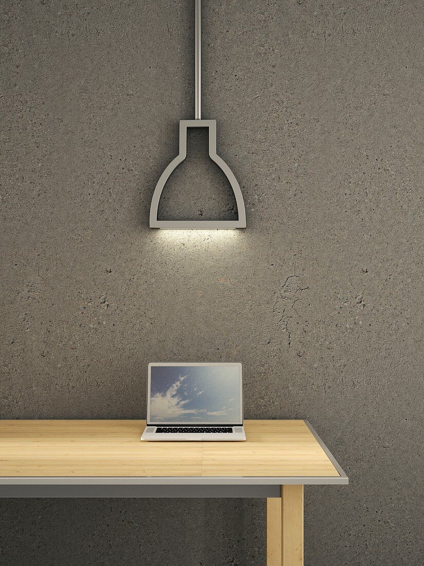 Laptop on wooden table below modern neon lamp against grey concrete wall