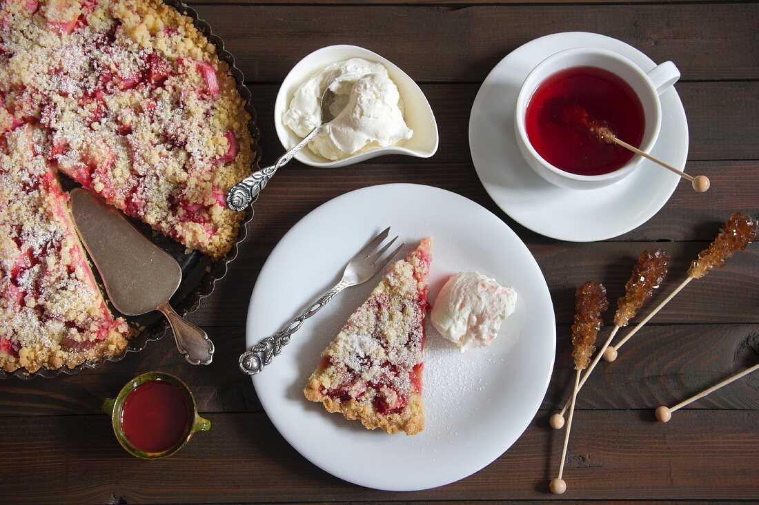 Strawberry and rhubarb cake with cream served with fruit tea (seen from above)