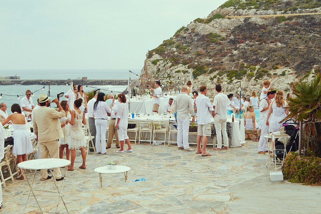 Hochzeitsgäste bei Poolparty auf Terrasse am Meer