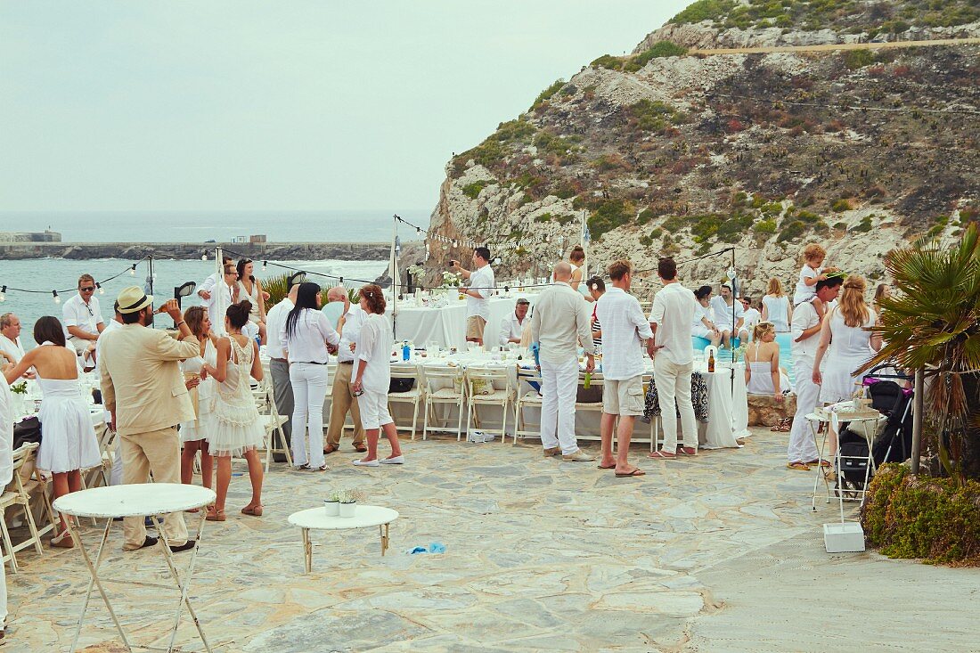 Wedding guests at a pool party on a terrace by the sea