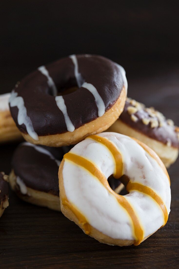 Doughnuts with various glazes on a wooden surface