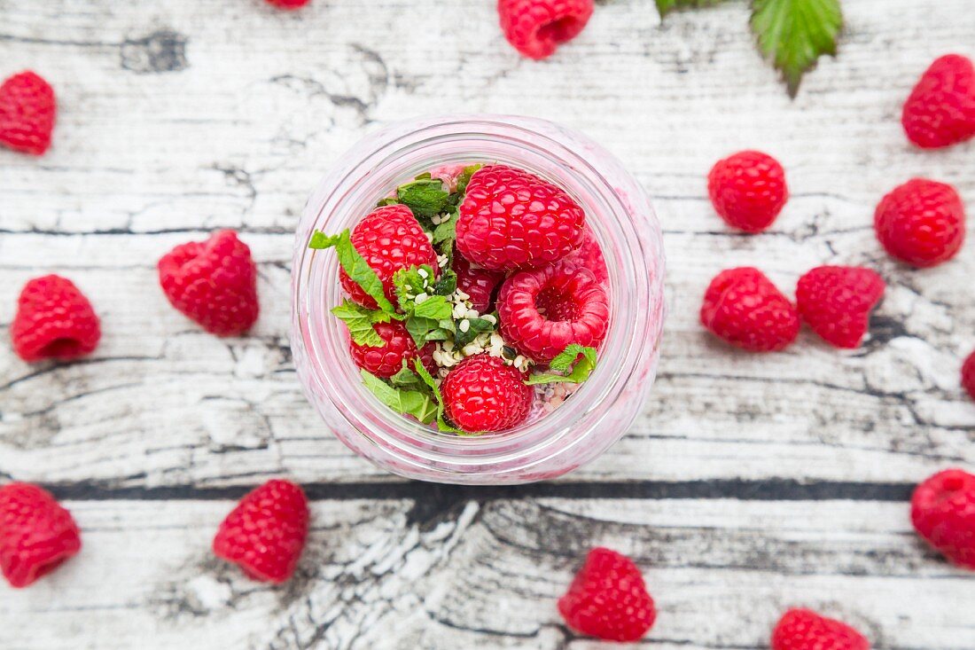 Frühstück im Glas mit Himbeeren Milch, Chia, Hanfsamen & Minze (Aufsicht)