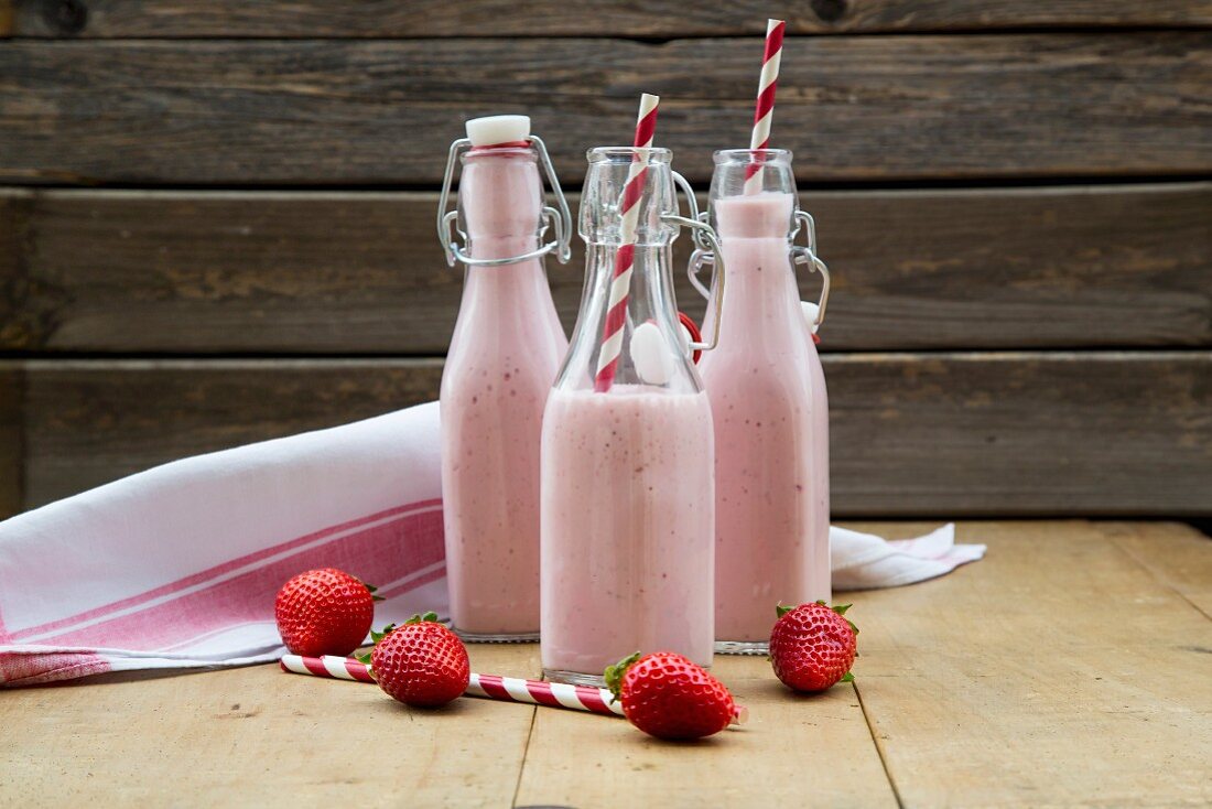 Strawberry smoothies in flip-top bottles with straws