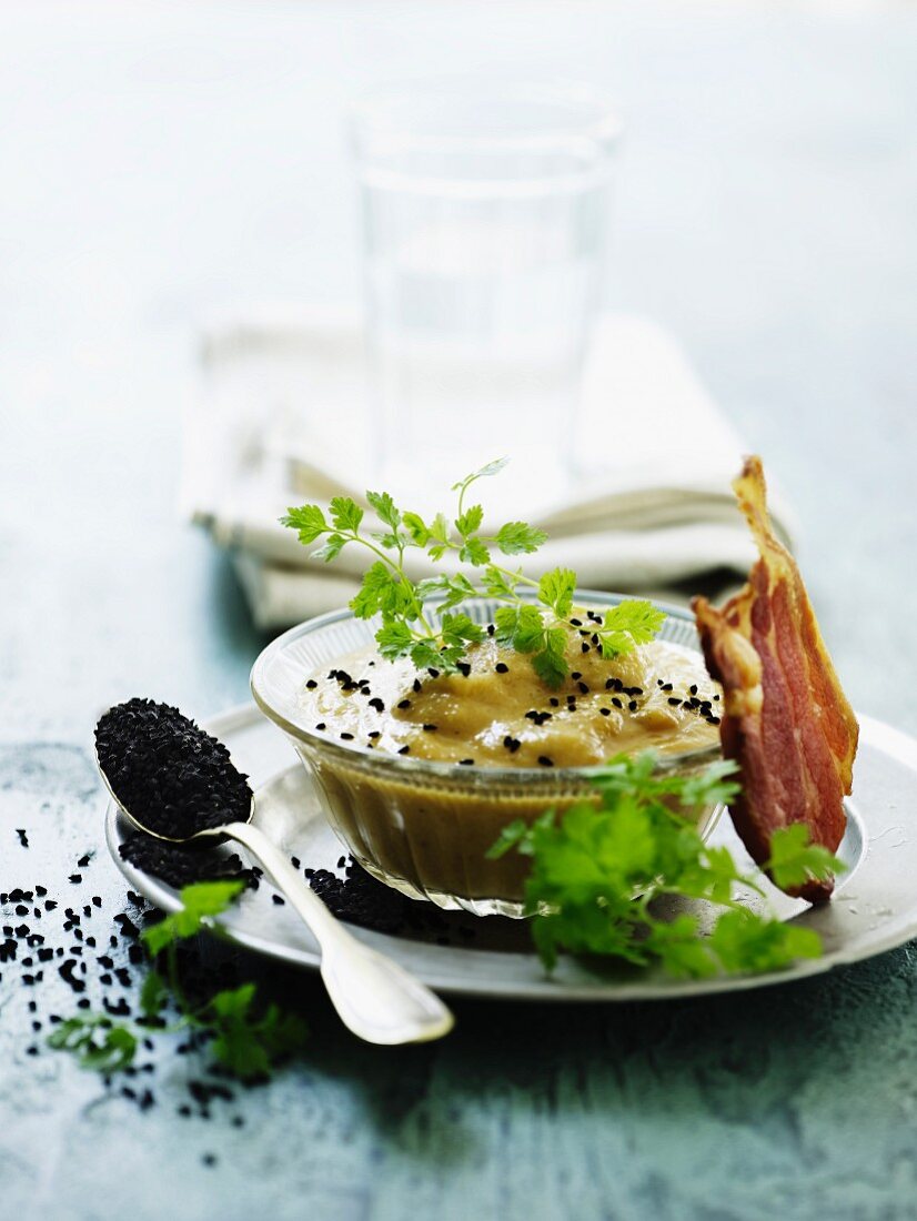 Cream of cauliflower soup with smoked fish and black sesame seeds