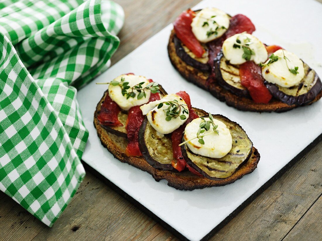 Crostini mit Tomaten, Auberginen und Ziegenrolle