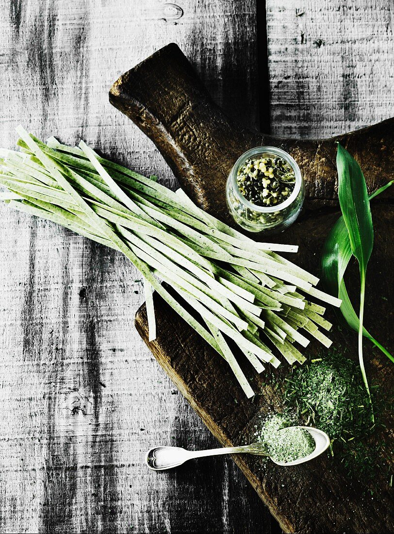 Wild garlic pasta with dry and fresh wild garlic on a wooden chopping board