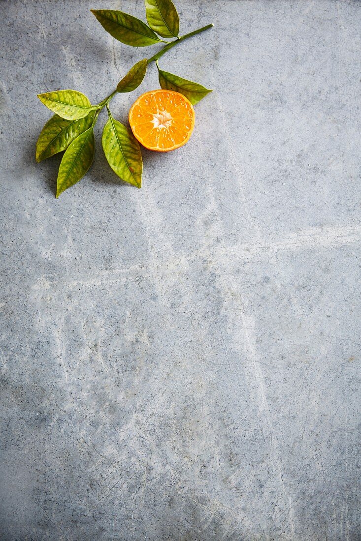 A halved clementine with leaves (seen from above)