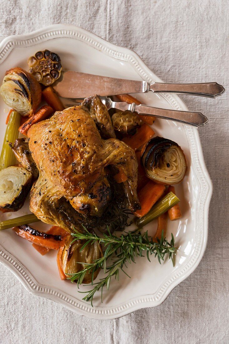 Roast chicken with lemon, vegetables and herbs