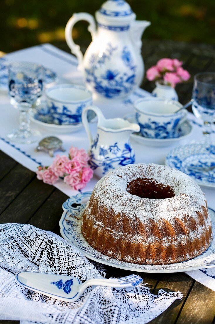 A Bundt cake on a table laid for coffee in the garden